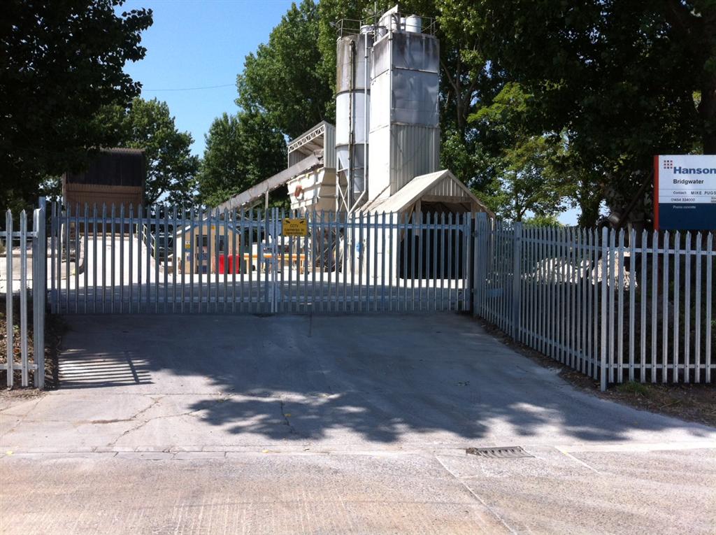 Steel palisade security fencing with matching gates at industrial premises